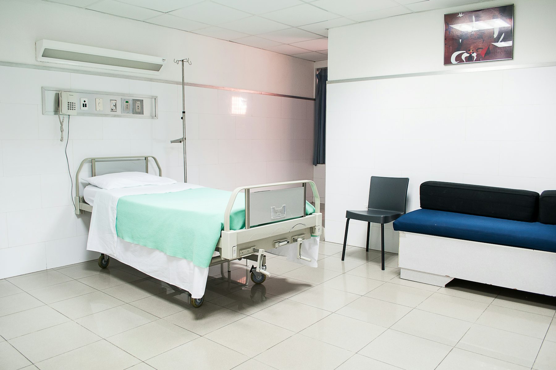 A treatment bed and a sofa in a pale clinic room