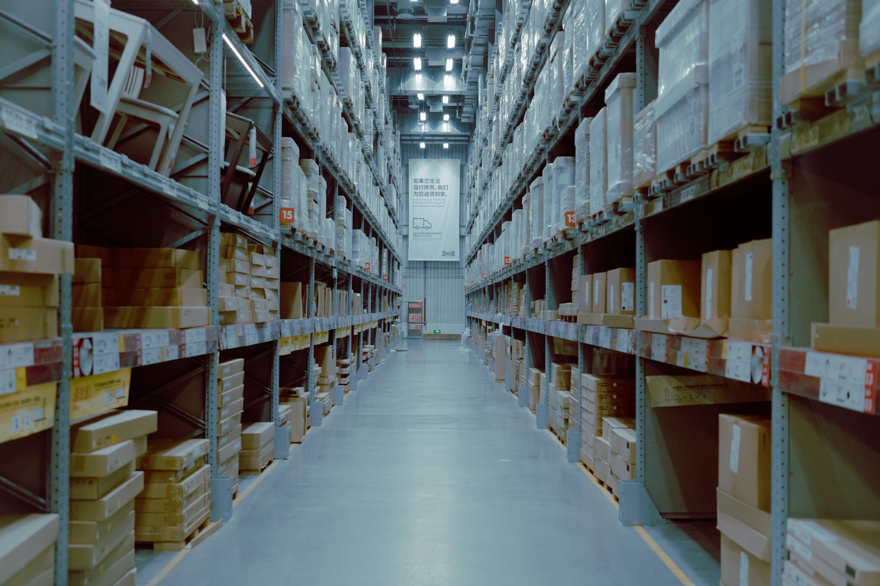 A long warehouse aisle between tall shelving